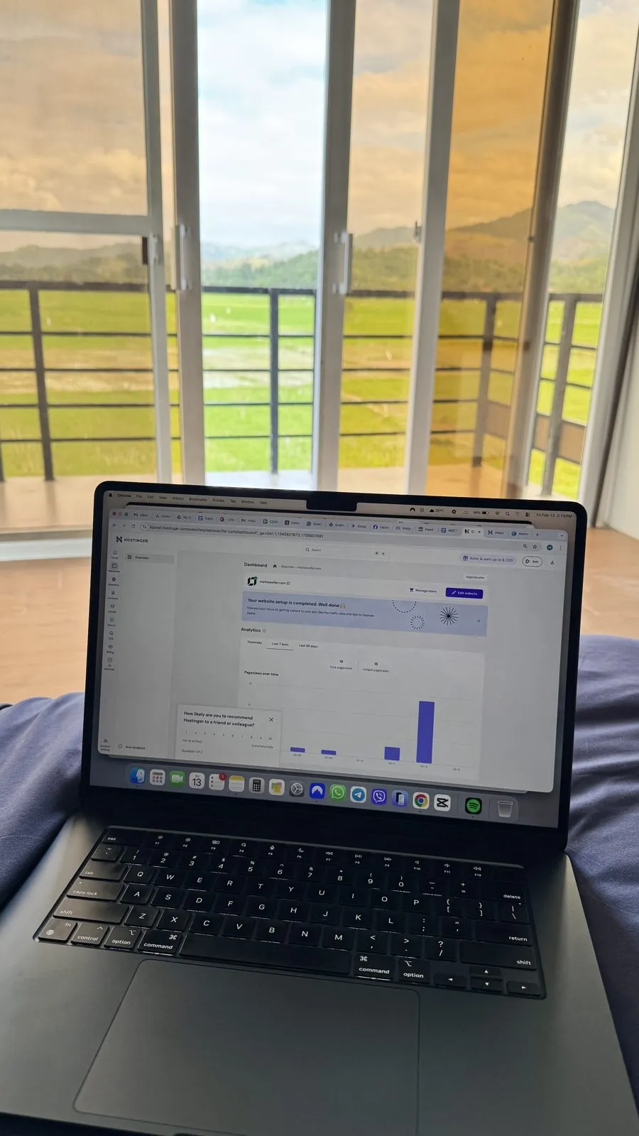 Website analytics dashboard on a laptop by an open window