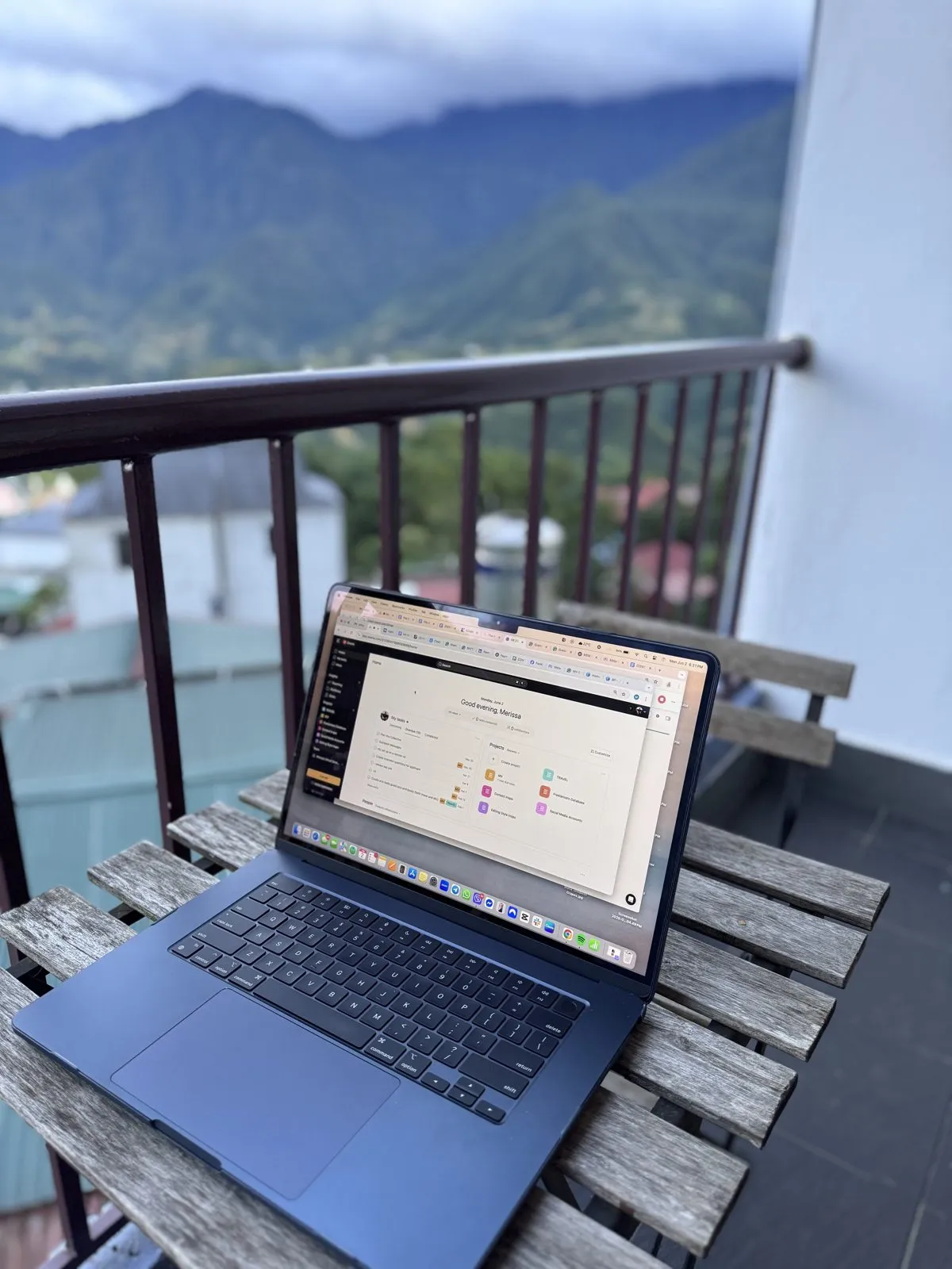 Asana workspace open on a laptop on a mountain balcony